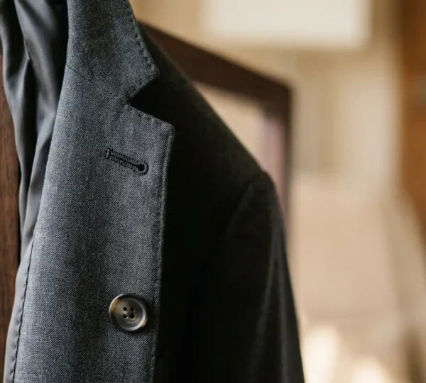 Professional business attire detail showcasing fabric texture and garment quality in elegant hotel setting