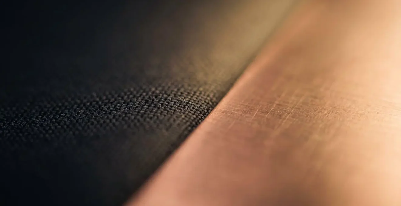 Abstract macro shot of two textures, fabric and metal, representing the balance between booking flexibility and opportunistic deals.