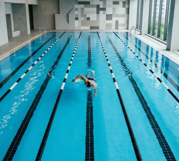 Professional swimmer performing freestyle stroke in modern hotel lap pool with clean lanes and optimal depth